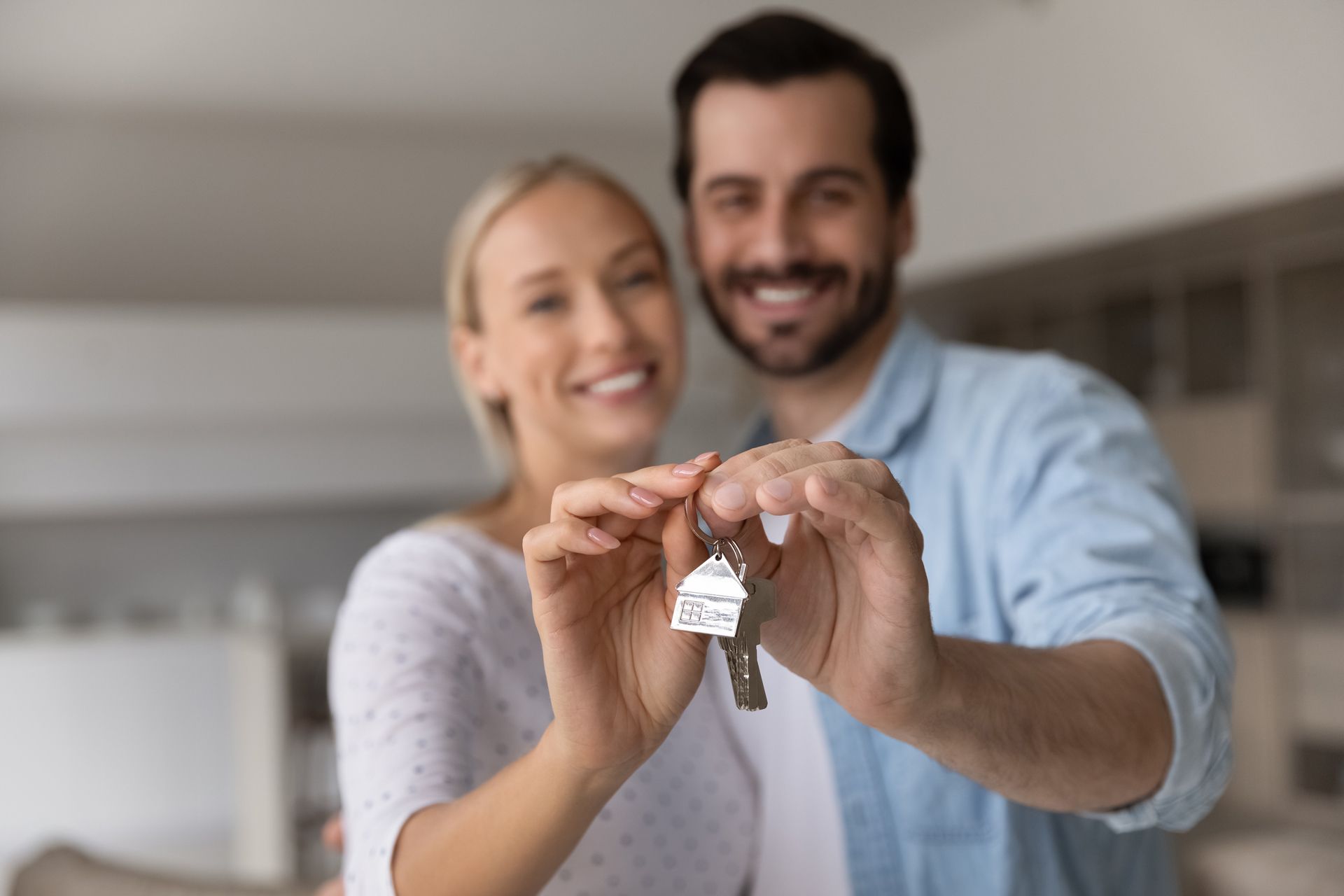 A Man and a Woman Are Holding Keys to Their New Home