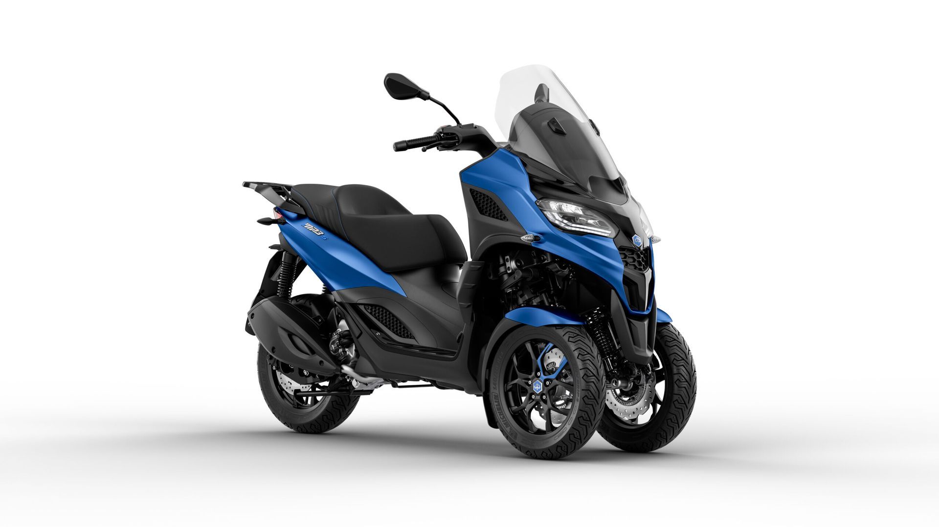 Uno scooter nero è parcheggiato su uno sfondo bianco.