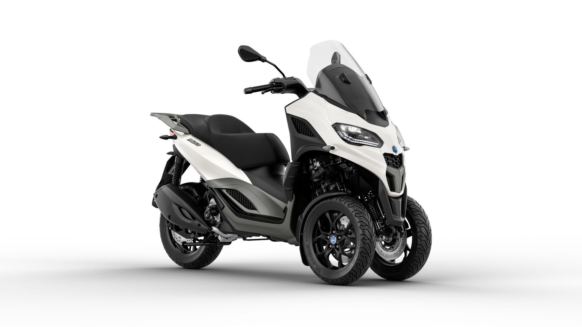 Uno scooter nero è parcheggiato su uno sfondo bianco.