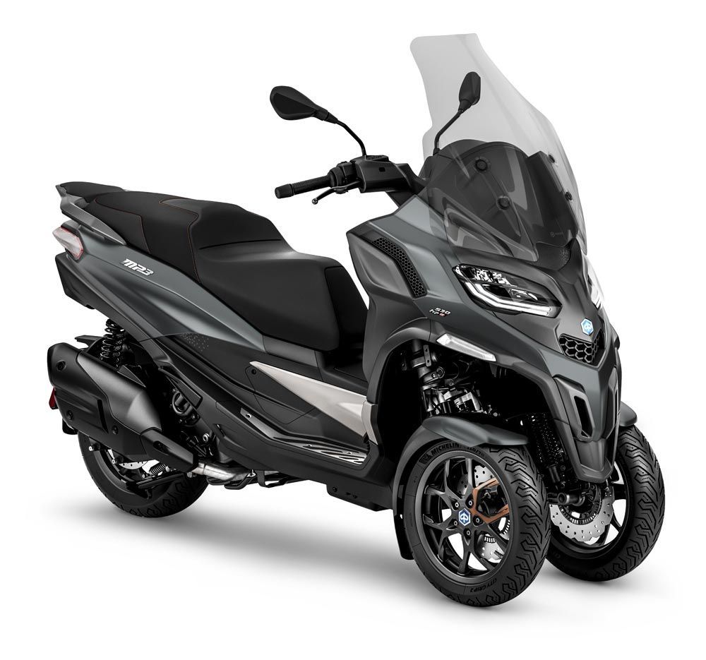 Uno scooter nero è parcheggiato su uno sfondo bianco.