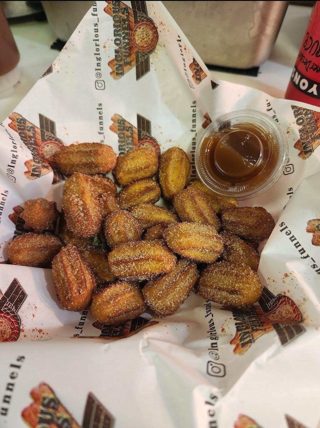 Tray of golden fried pastries beside a bowl of chocolate sauce