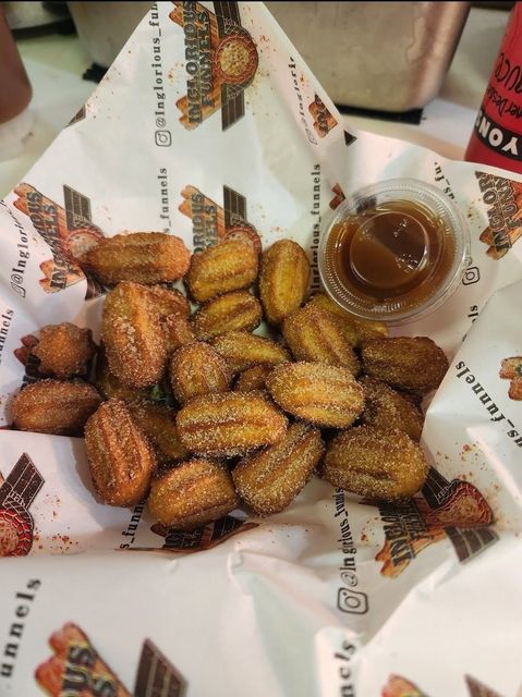 Tray of golden fried pastries beside a bowl of chocolate sauce
