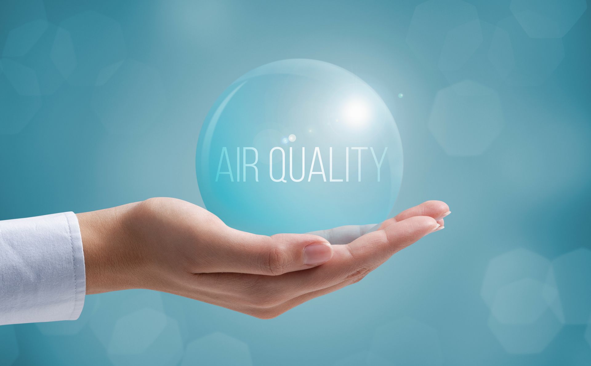 Hand balancing a clear bubble to represent solutions for indoor air quality.