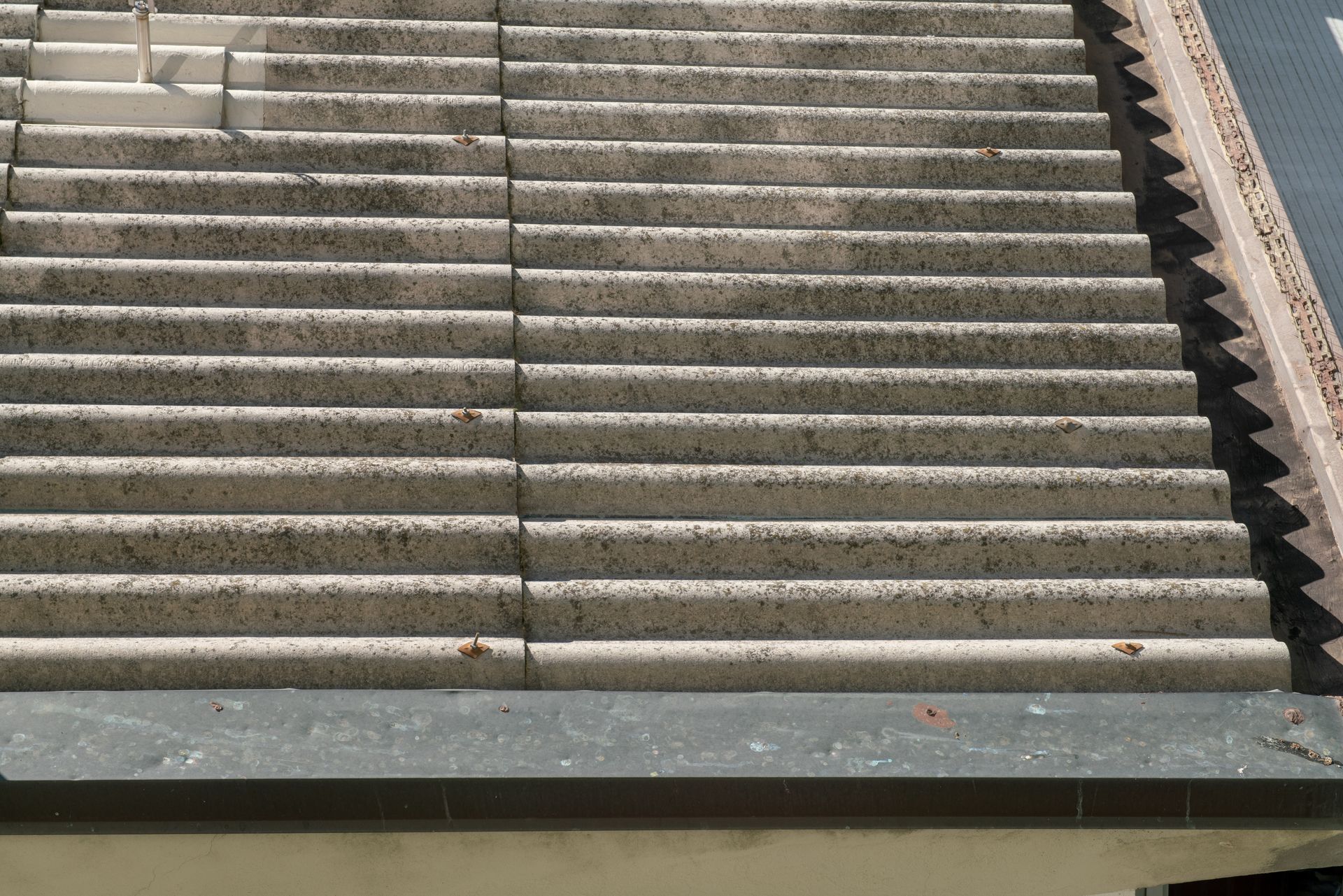Weathered corrugated roof panels showing surface staining and aging on a building rooftop.