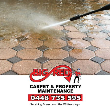 A Person Is Cleaning A Stone Wall With A High Pressure Washer — Big Red Carpet & Property Maintenance In Bowen, QLD A Person Is Cleaning A Stone Wall With A High Pressure Washer — Big Red Carpet & Property Maintenance In Bowen, QLD