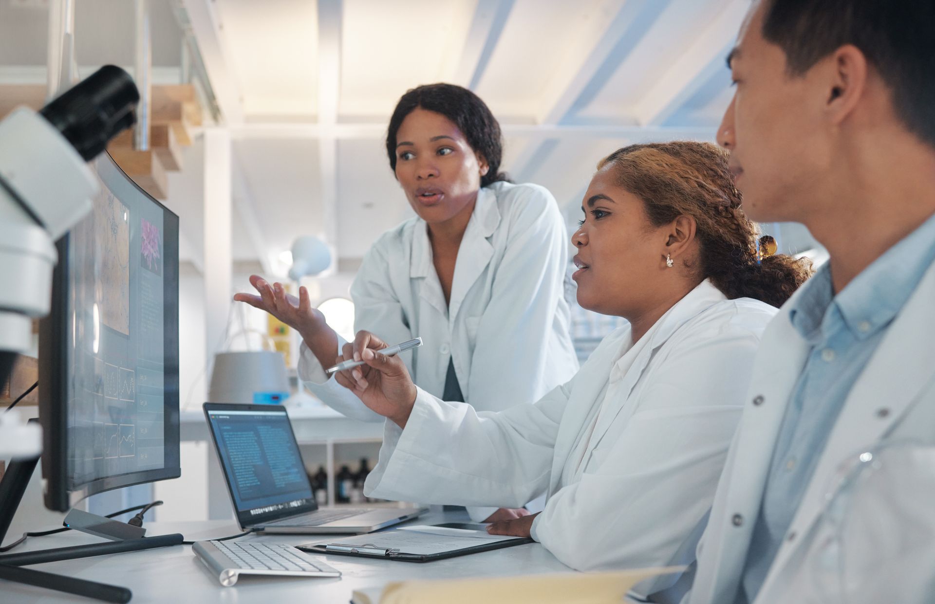 A group of scientists are looking at a computer screen in a lab.