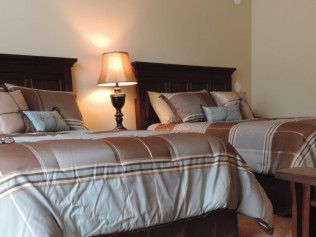 A bedroom with two beds and two lamps
