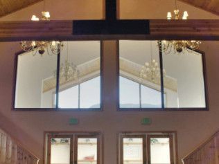 A church with a cross on the ceiling and a lot of windows.