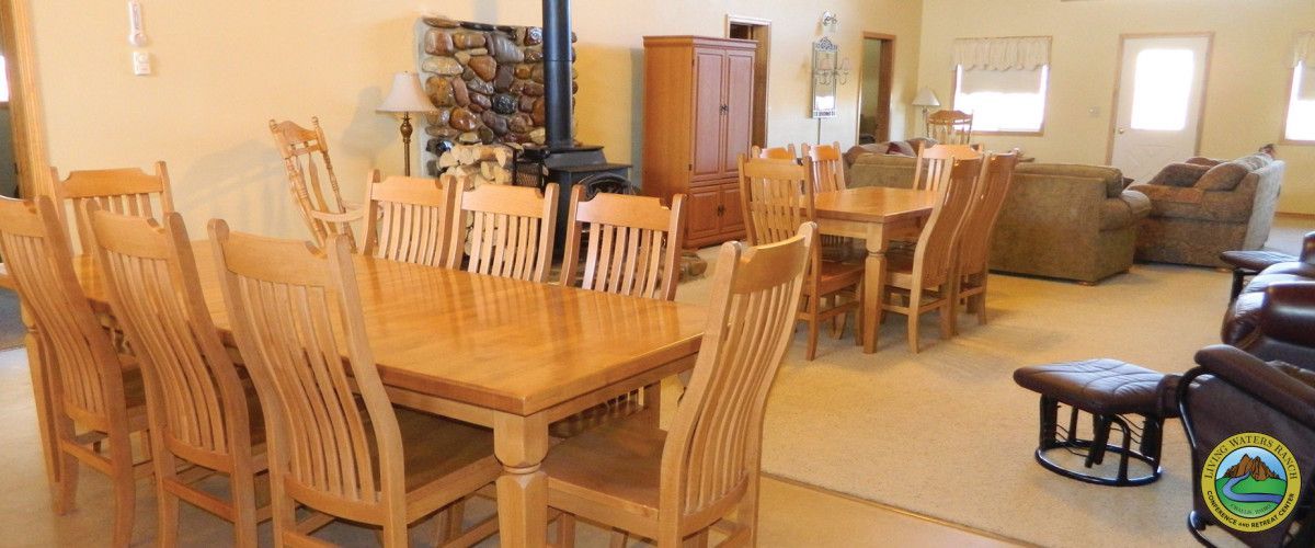 A large dining room table and chairs in a living room.