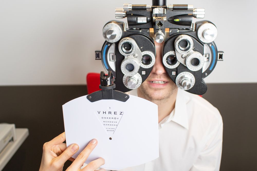 A Man Is Getting His Eyes Checked by An Ophthalmologist — New Look Eyewear In Maitland, NSW
