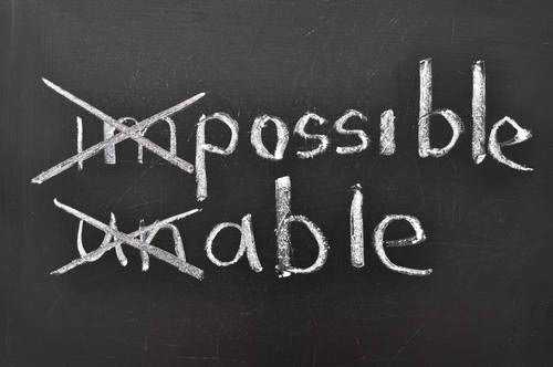 “Impossible” crossed out and replaced with “possible” in white chalk on a blackboard