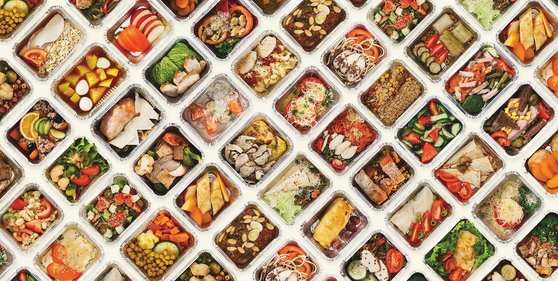 Colorful assortment of vegetables and food in white lattice trays at a market display