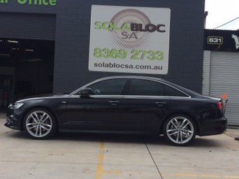 A Black Car Is Parked In Front Of A Building That Says Sola Bloc SA – Adelaide, SA - Sola Bloc Window Tinting