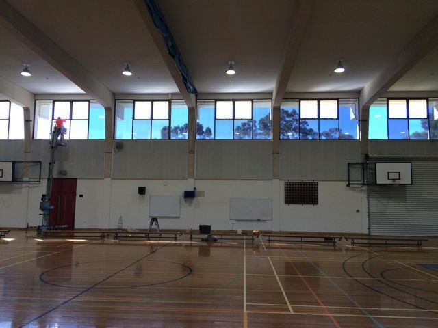 A Man Is Cleaning The Windows Of A Gym – Adelaide, SA - Sola Bloc Window Tinting