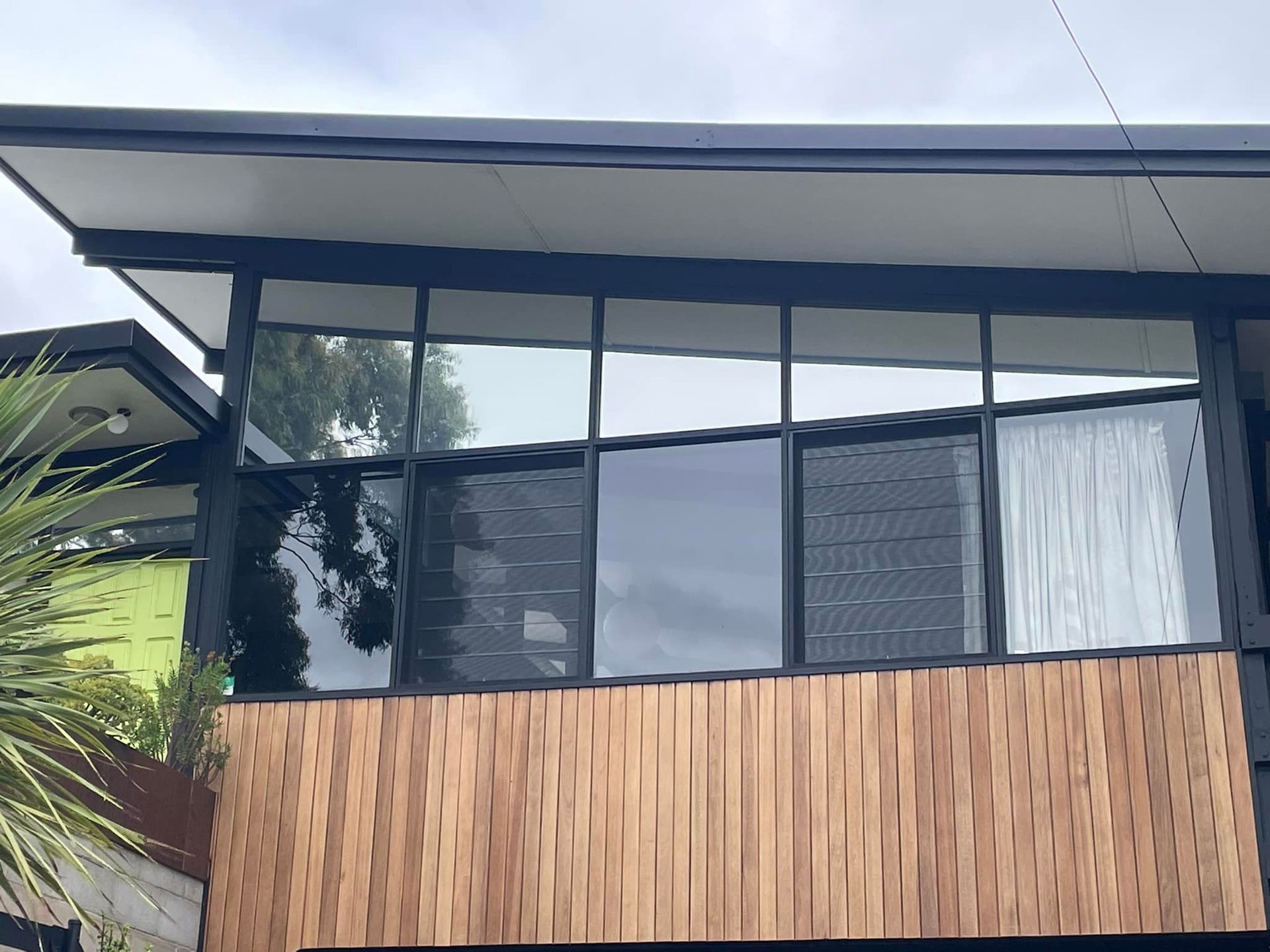 A House With A Lot Of Tinted Windows And A Wooden Facade – Adelaide, SA - Sola Bloc Window Tinting
