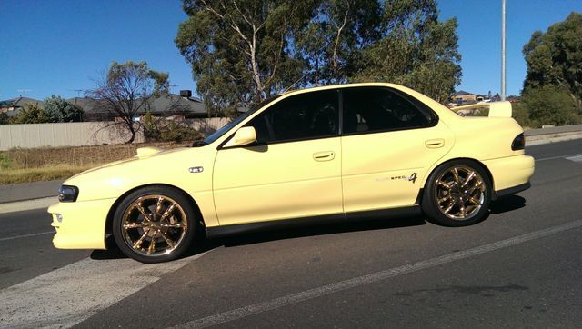 A Yellow Car Is Parked On The Side Of The Road – Adelaide, SA - Sola Bloc Window Tinting