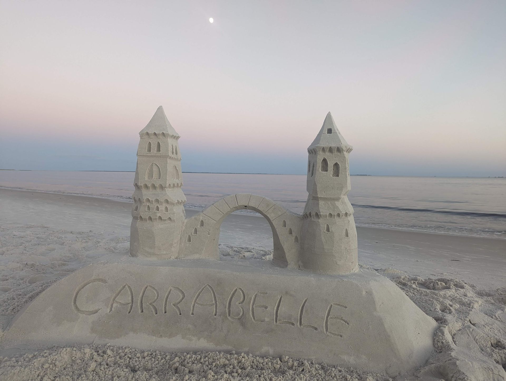 Sandcastle on beach with bridge, towers, and 