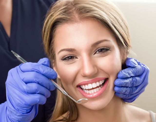 A Woman Is Getting Her Teeth Examined By A Dentist — Port Denture Clinic In Port Macquarie, NSW