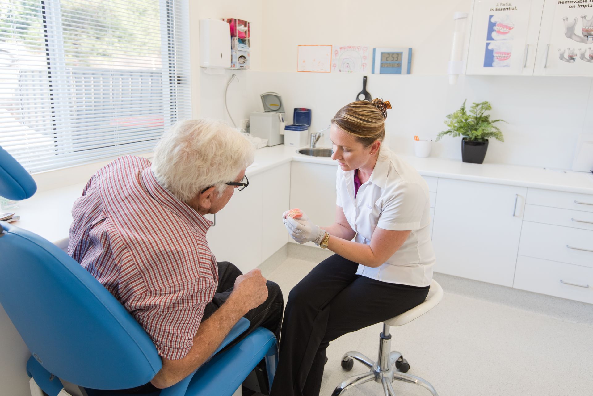 A man is getting a denture made by a dentist. — Port Denture Clinic In Bonny Hills, NSW