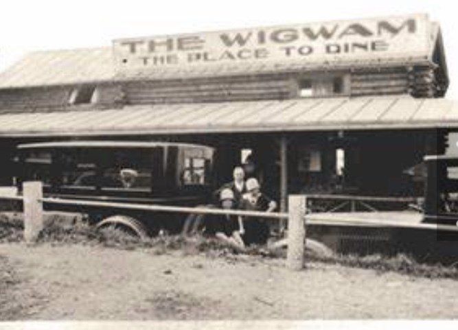 Vintage black-and-white photo of a log building labeled 