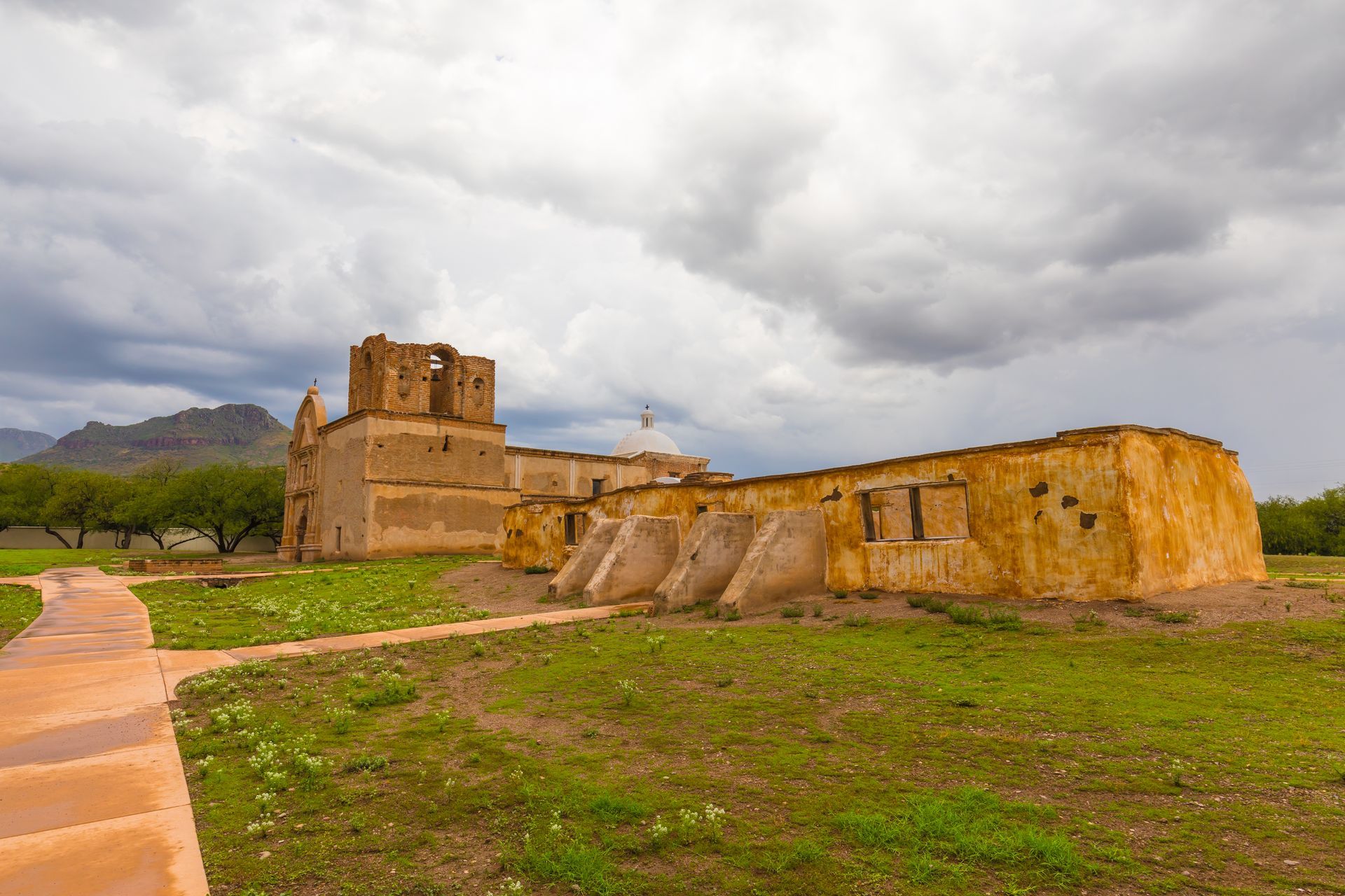 A large building is sitting in the middle of a grassy field.