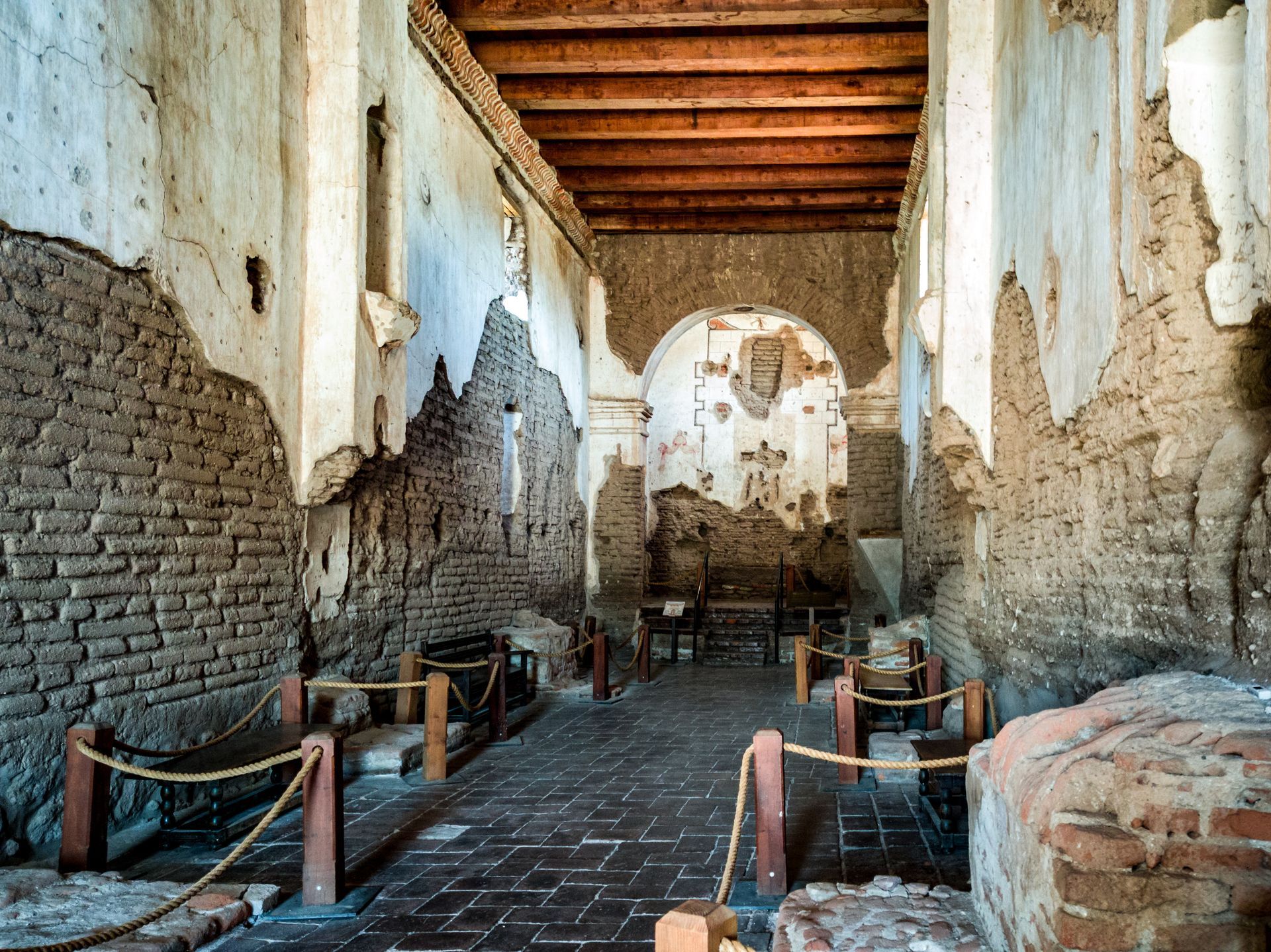 The inside of an old building with brick walls and wooden beams.