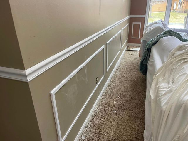 A living room with a couch and a wall with molding.