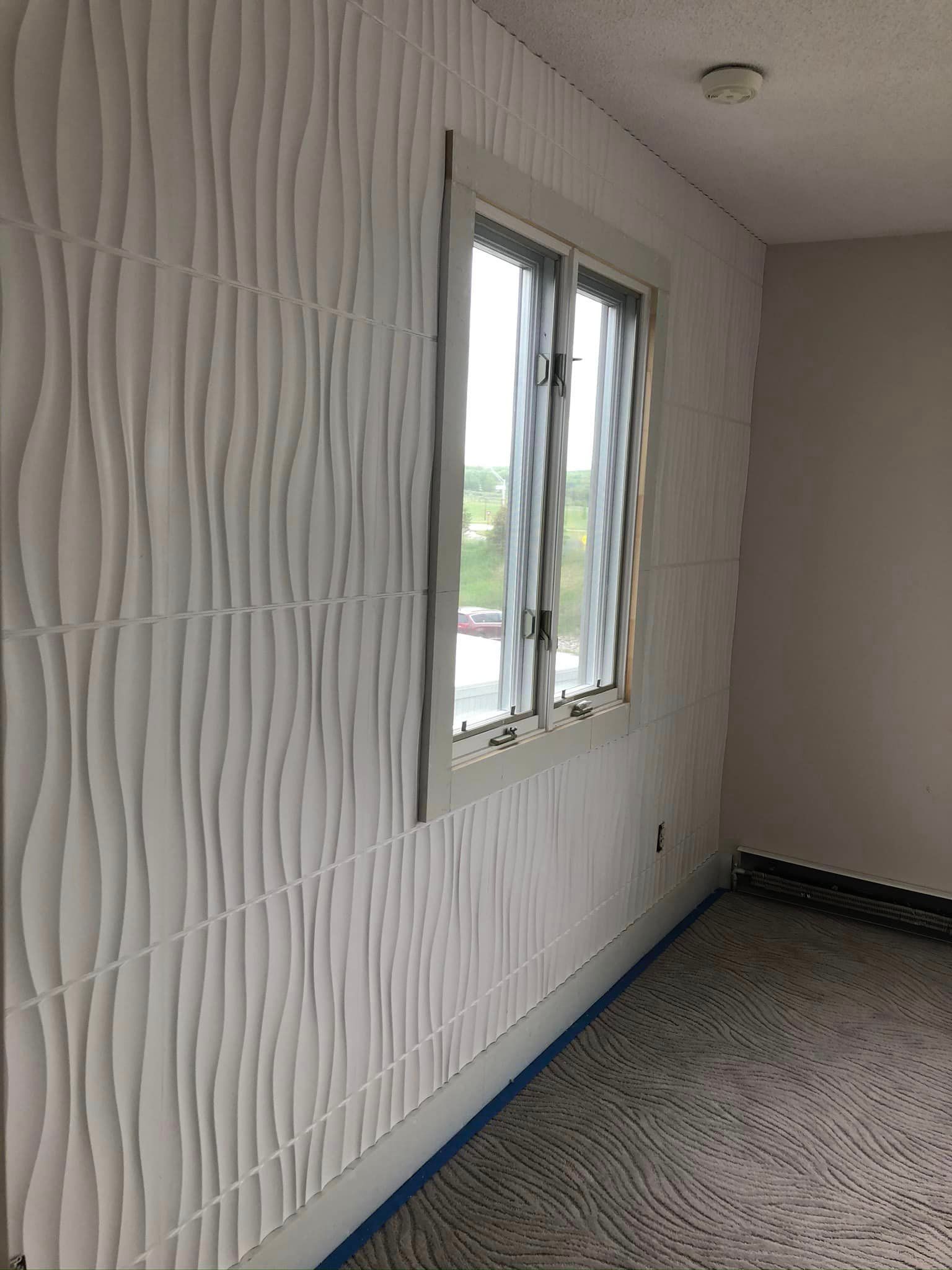 A room with a white wall and a window.
