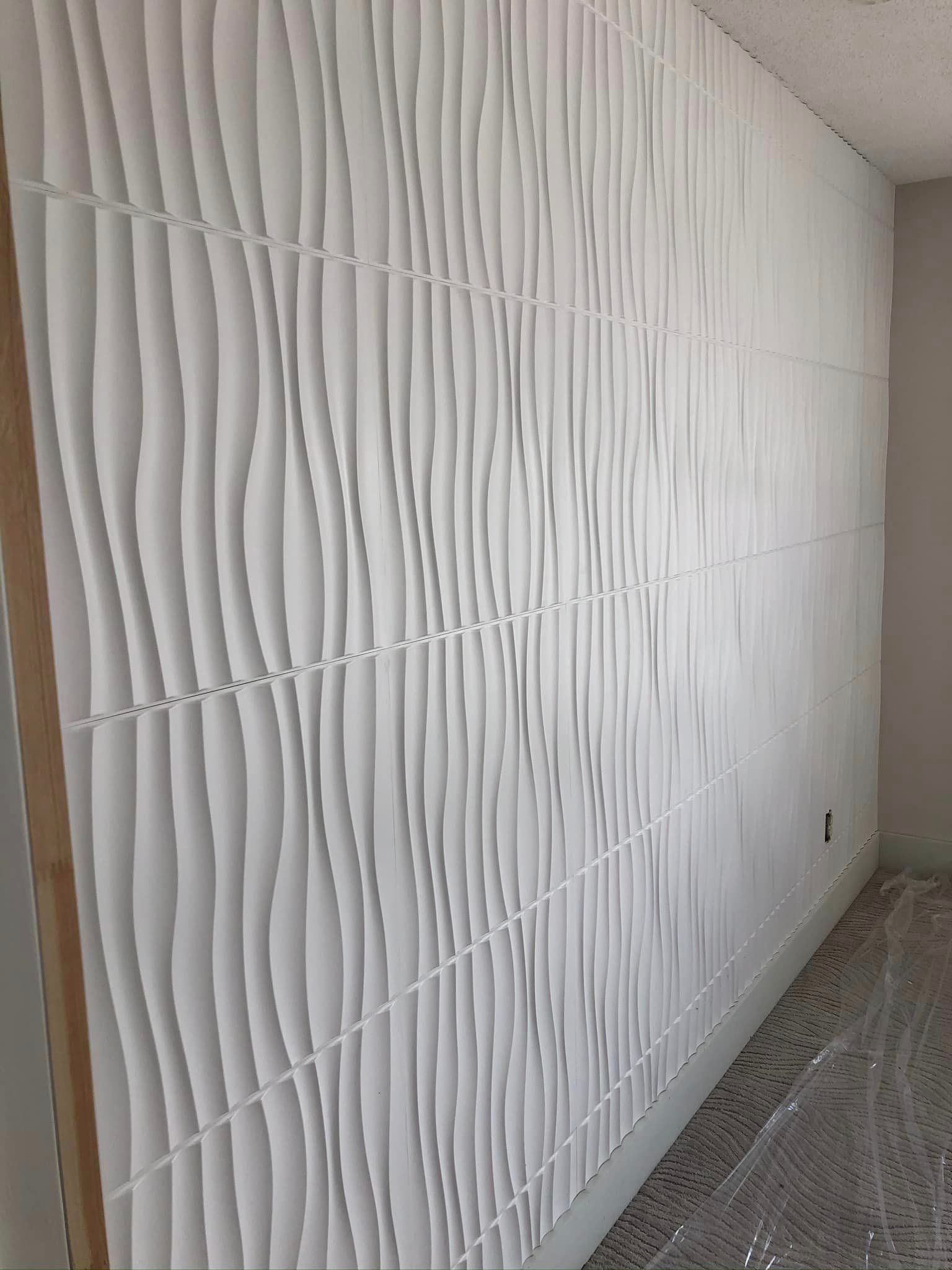A white wall with a pattern on it is being built in a room.