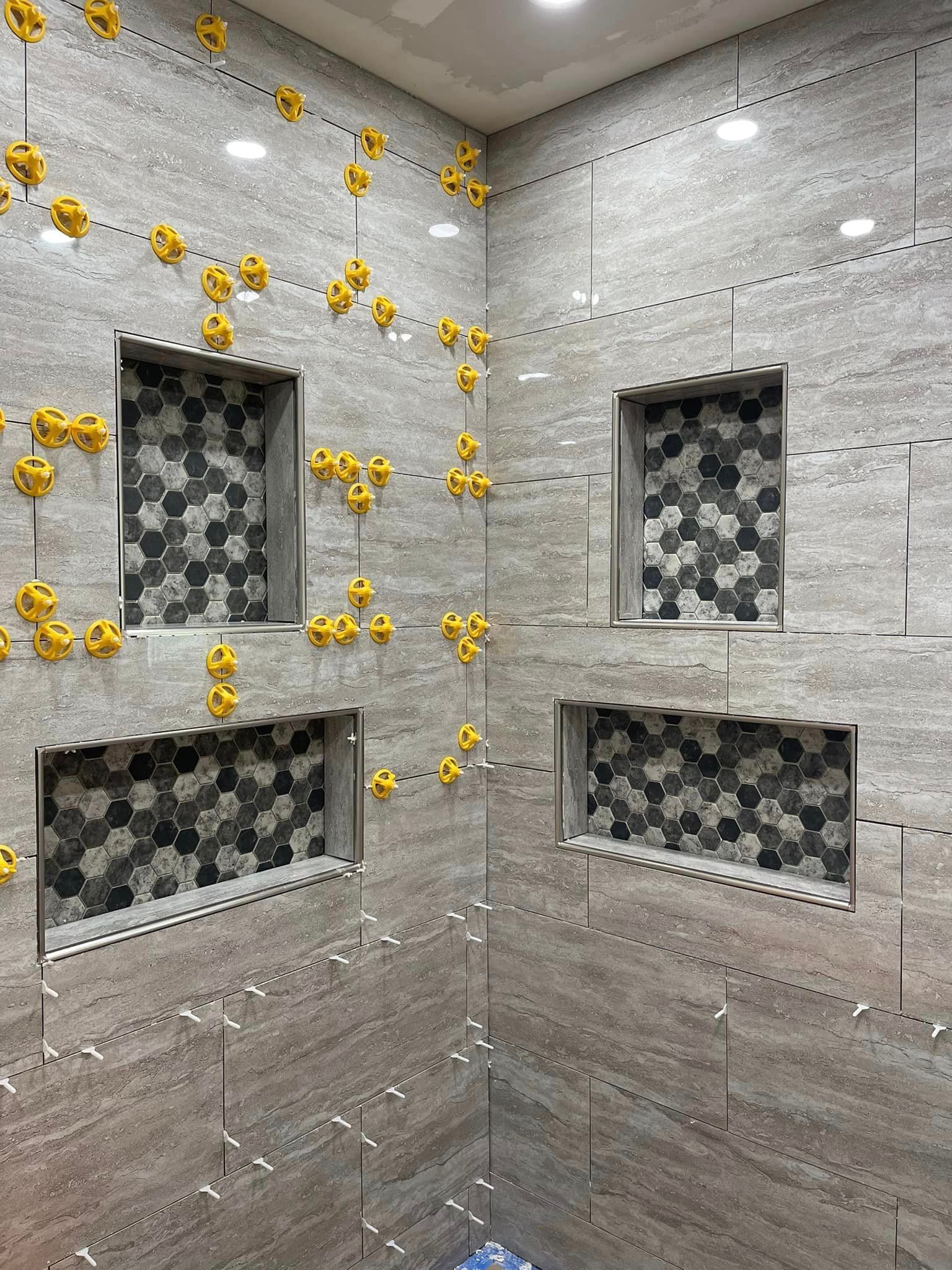 A bathroom with a lot of tiles and holes in the wall.