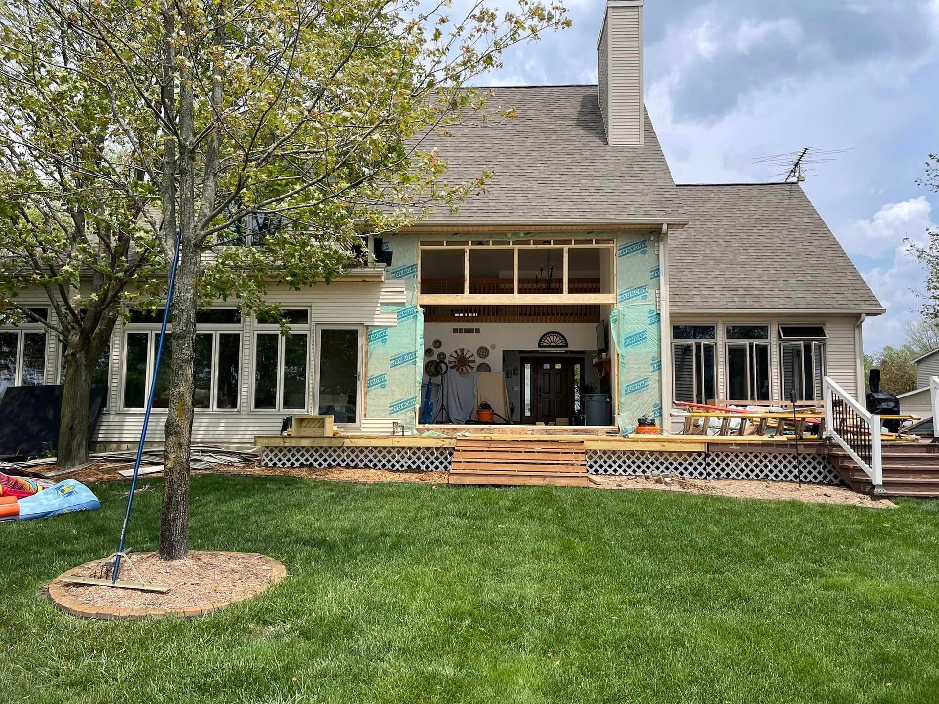 A large house with a large lawn in front of it is being remodeled.