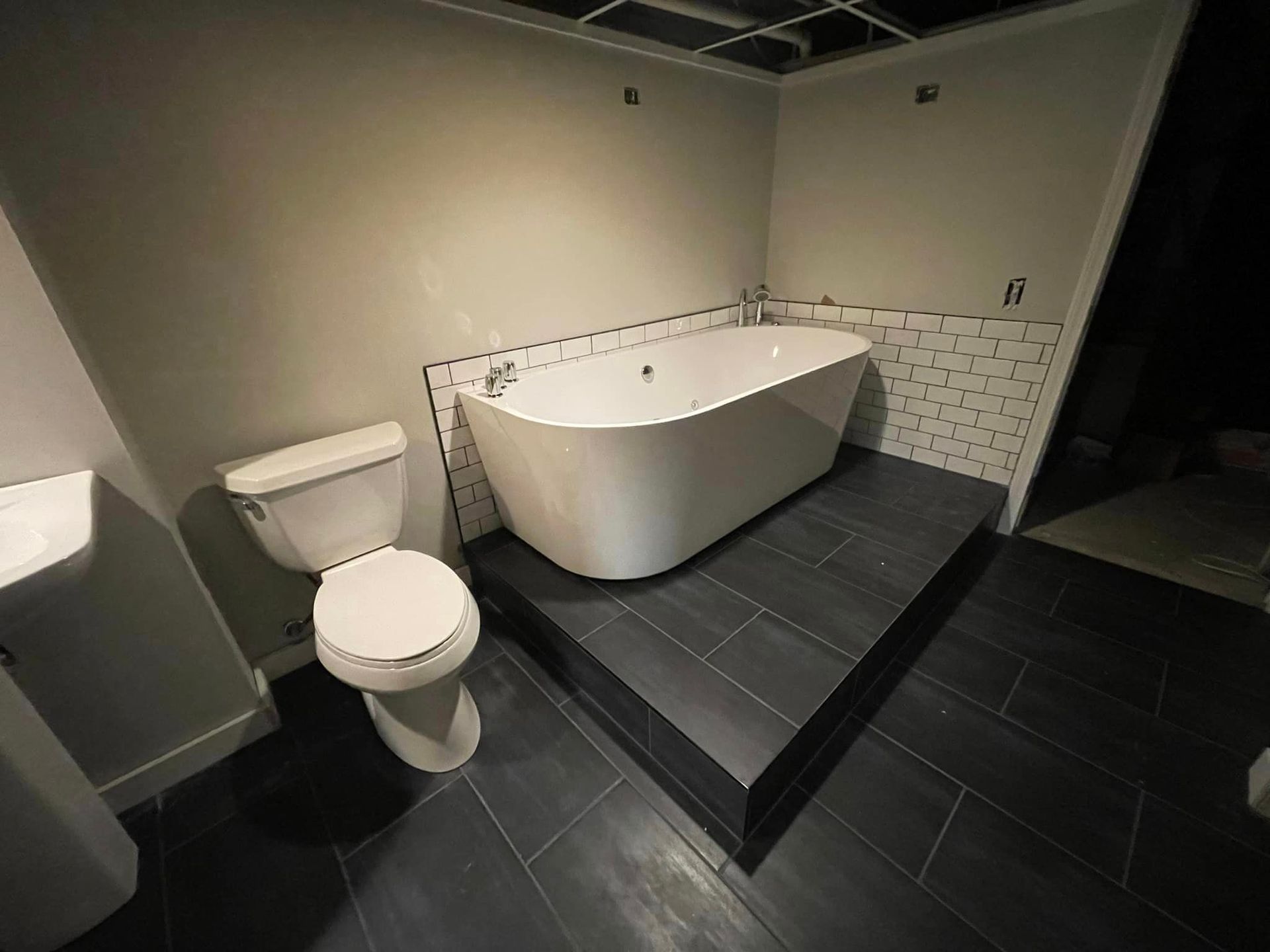 A bathroom with a toilet , sink and bathtub.
