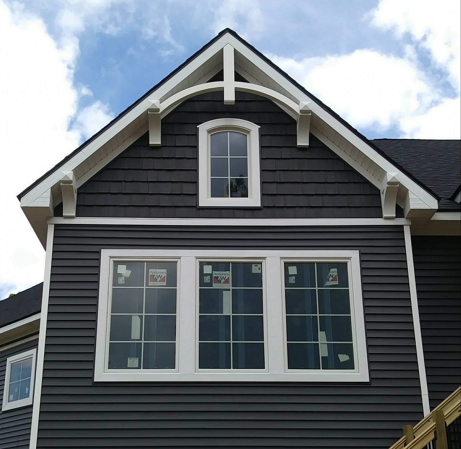 A black house with white trim and a large window