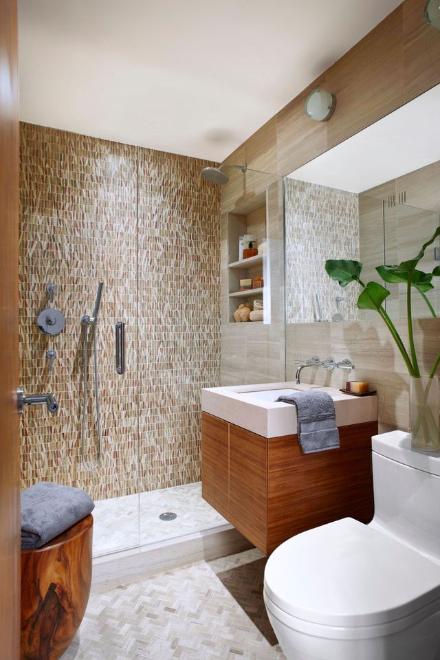 A bathroom with a toilet , sink , shower and mirror.