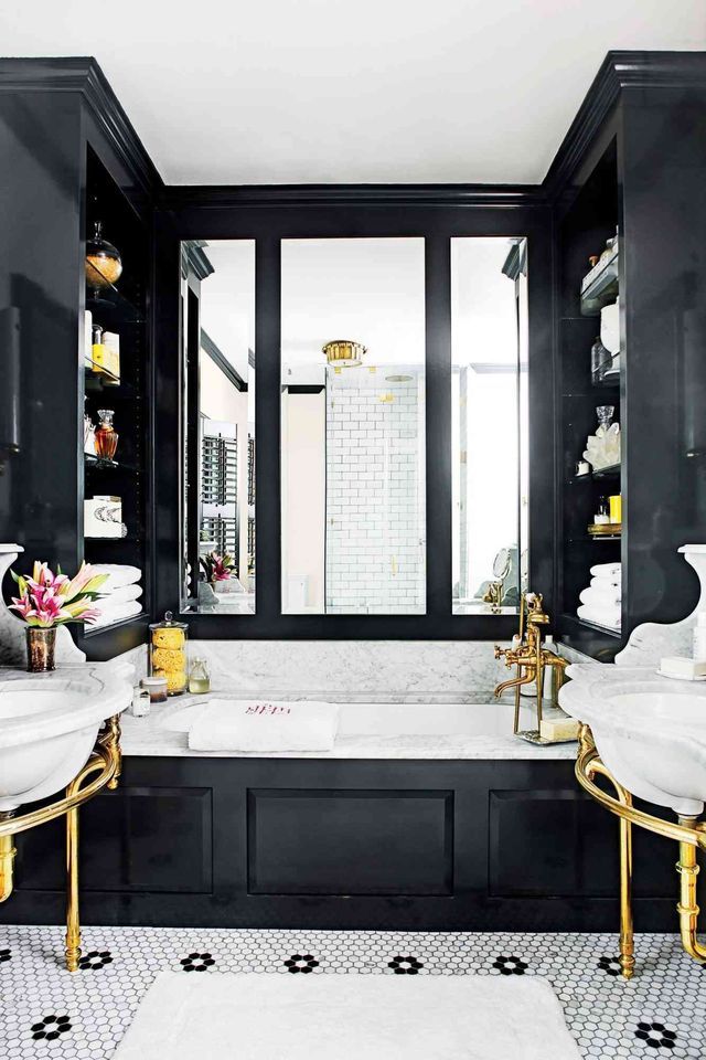 A bathroom with two sinks , a tub and a mirror.