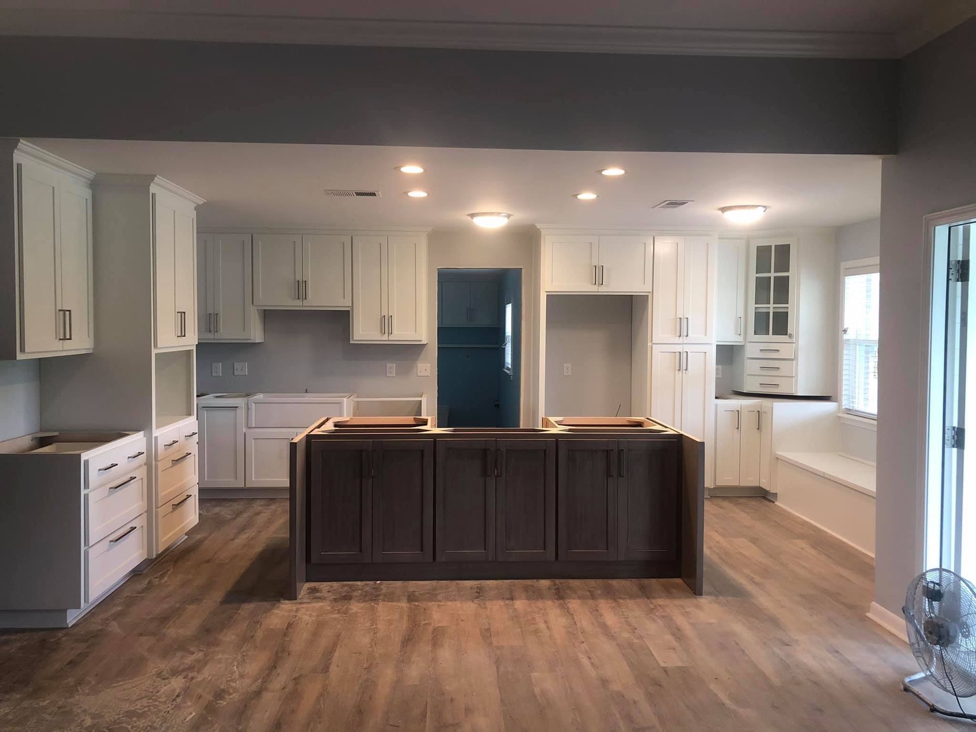 A kitchen with white cabinets and a large island in the middle of the room.