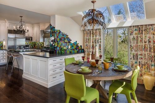 A kitchen and dining room with a round table and green chairs.