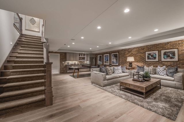 A living room with a staircase leading up to the second floor.