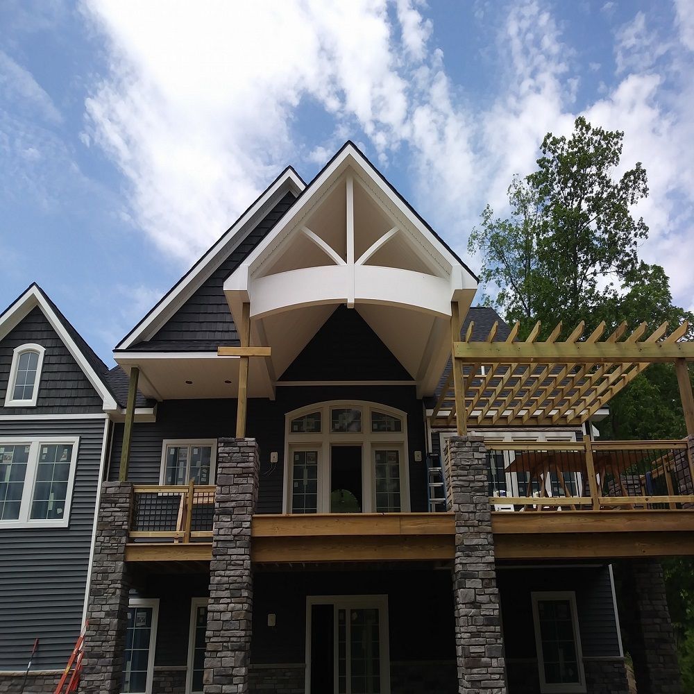 A large house with a large deck and a pergola