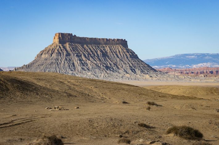 Flat-topped mesa in a dry desert landscape under a clear blue sky