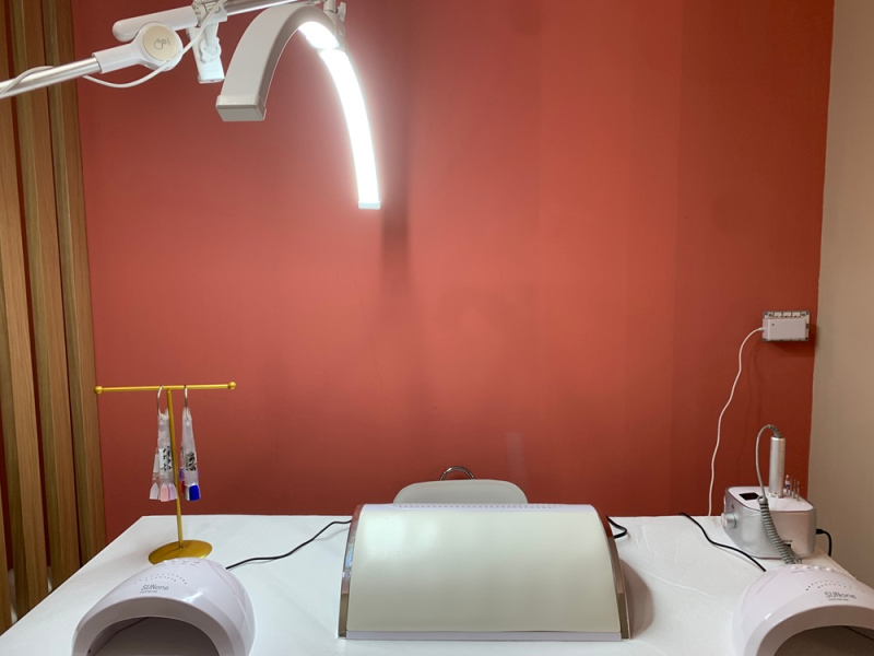 Poltrona da studio dentistico con lampada a soffitto e parete rossa, sala di trattamento vuota.