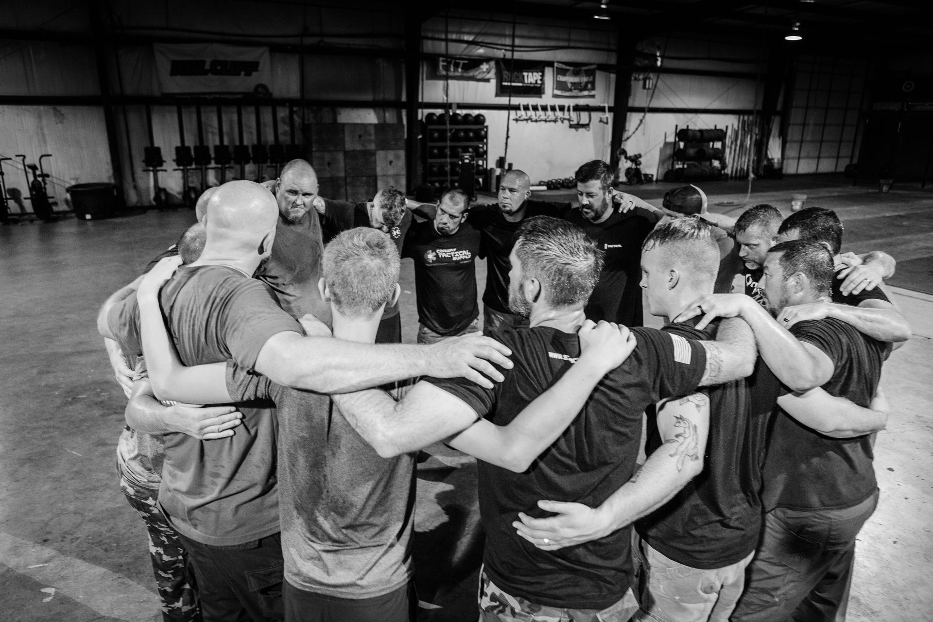 A group of men are standing in a circle with their arms around each other.