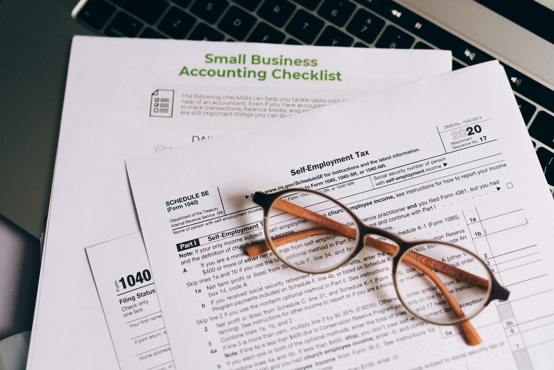 A pair of glasses is sitting on top of a small business accounting checklist.