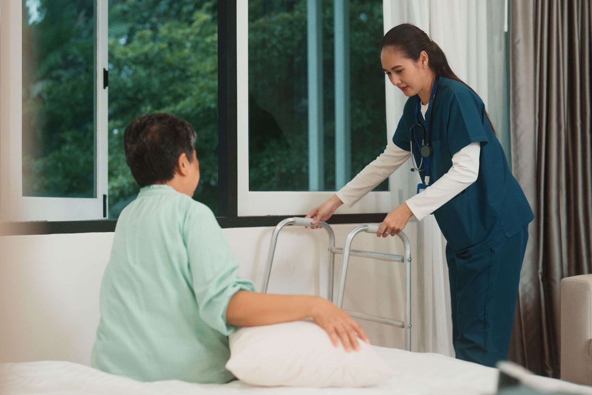 Home after surgery caregiver assisting elderly man with walker at home.