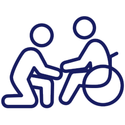 Person assisting a person in a wheelchair, kneeling to provide support.