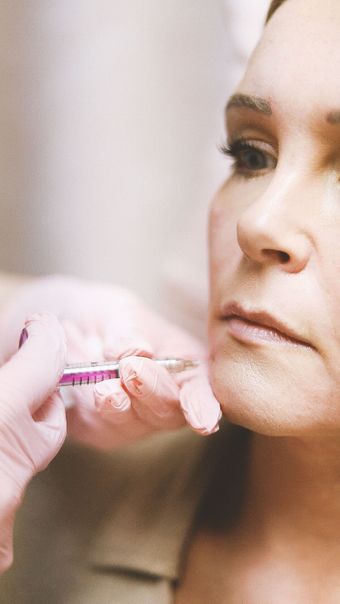 Close-up of a person receiving a facial injection near the cheek