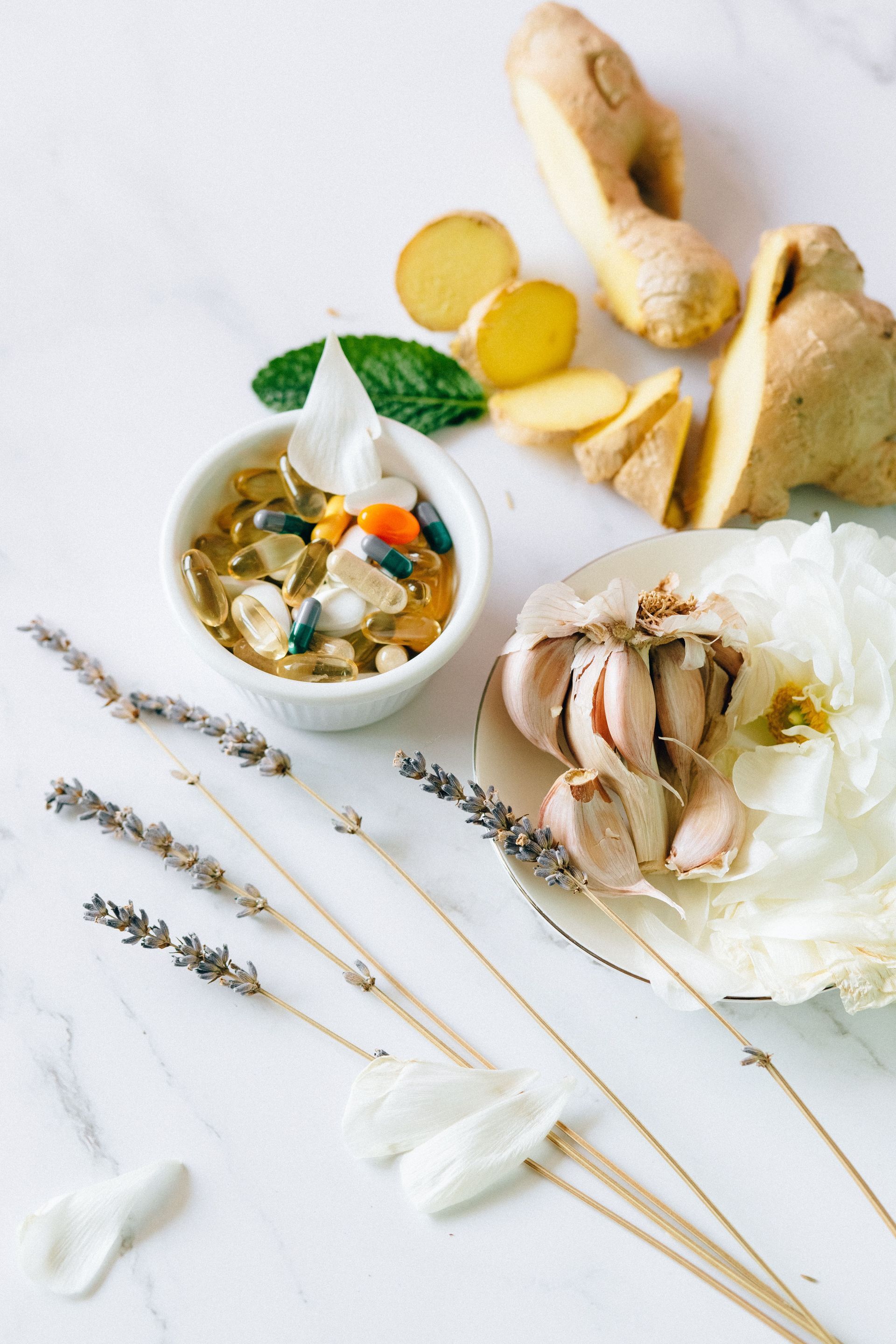 Tea, ginger slices, and dried wheat arranged on a white background