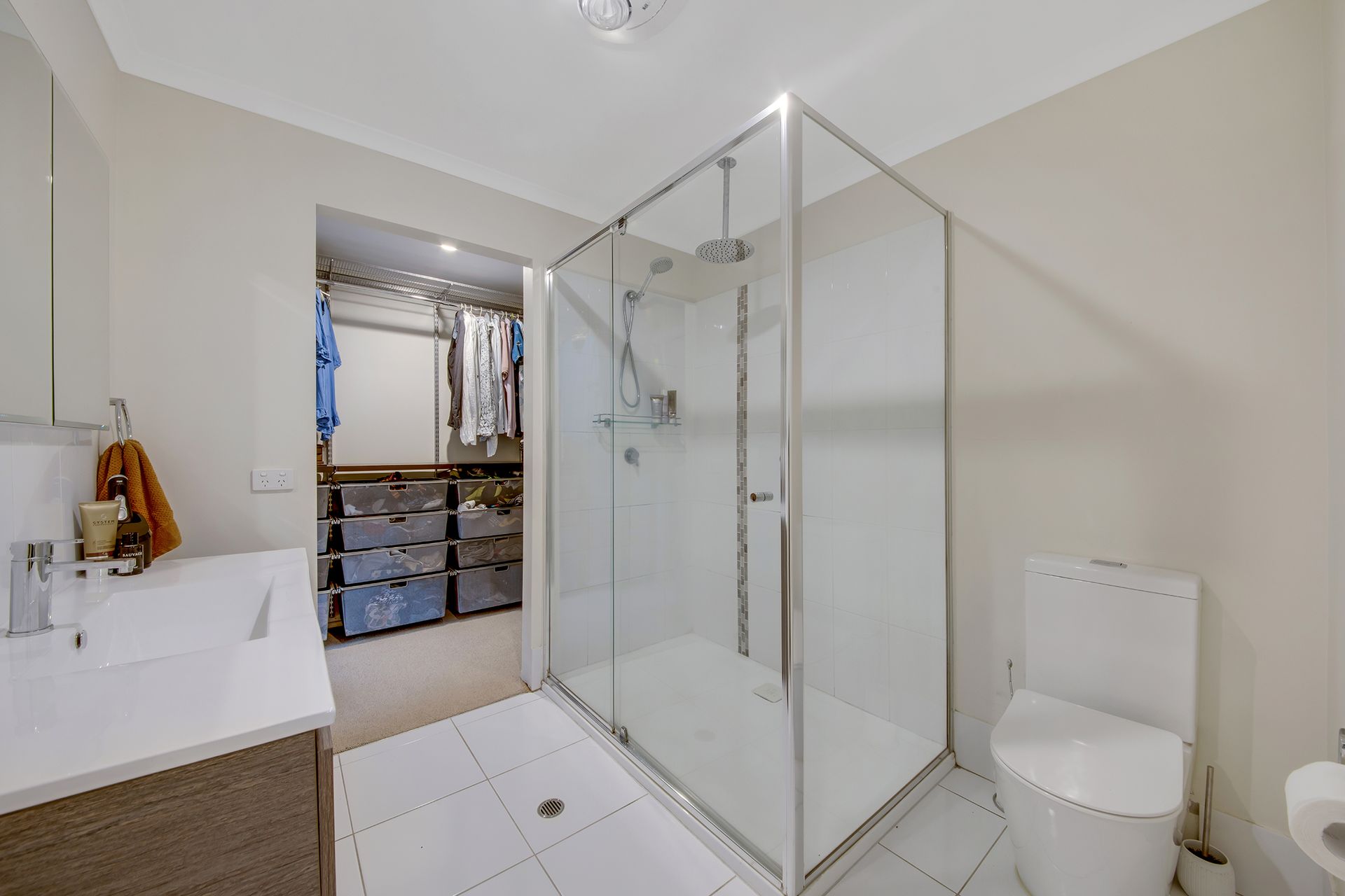 Bathroom with A Shower, Toilet, Vanity, and Walk-In Closet in A Neutral Color Scheme — Wares Blinds, Screens & Awnings In Gracemere, QLD