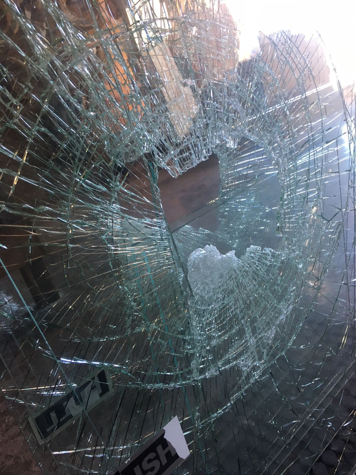 Shattered Glass Window With a Hole in the Center, Reflecting Sunlight and Fragments — Wares Blinds, Screens & Awnings In Gladstone Central, QLD