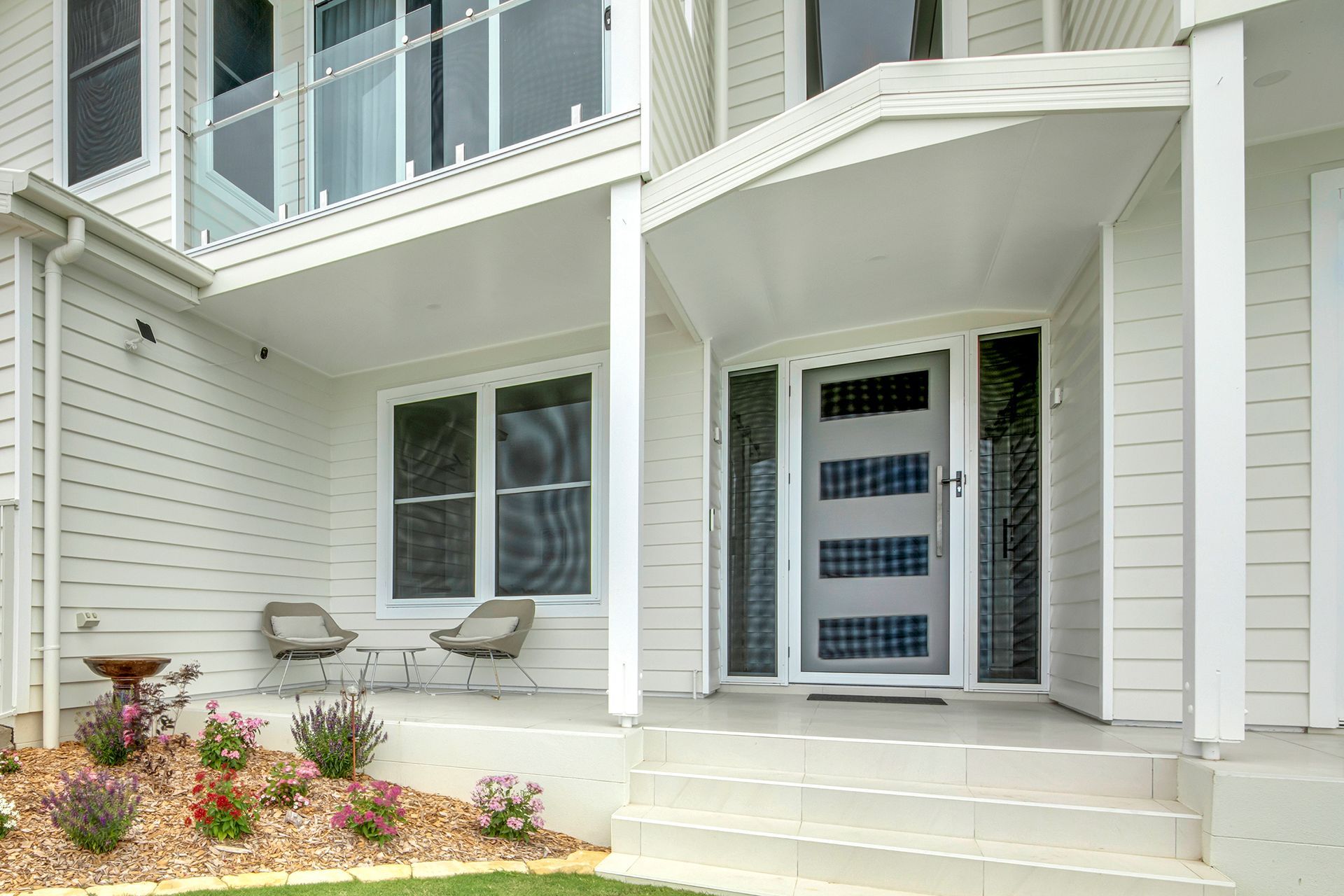 White House with Front Porch, Glass Door, and Flower Beds — Wares Blinds, Screens & Awnings In Yeppoon, QLD